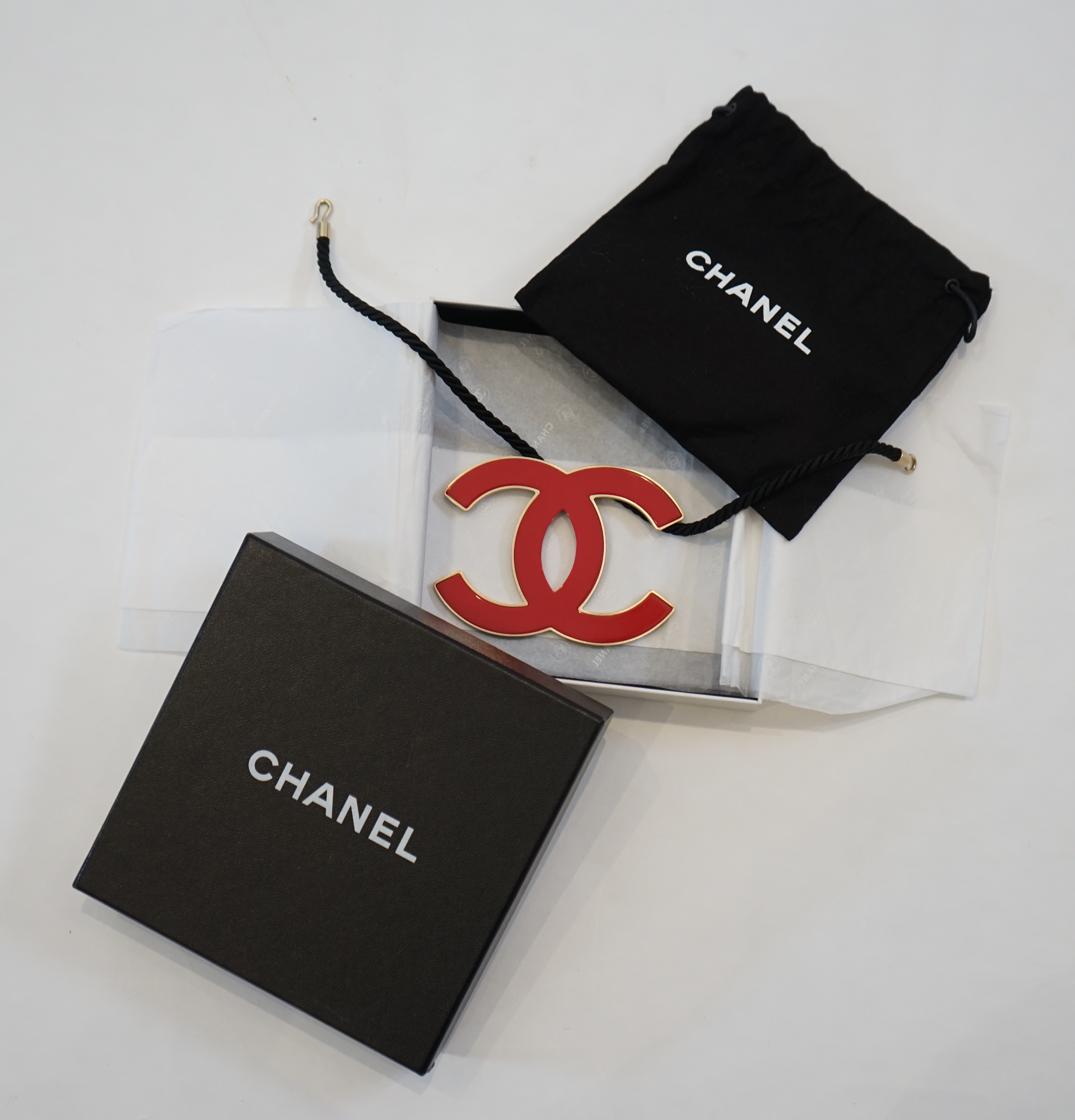 A Chanel CC red metal enamel and gold hardware fabric large choker evening necklace, cord length 39.5cm, charm width 10.75cm, height 8.25cm